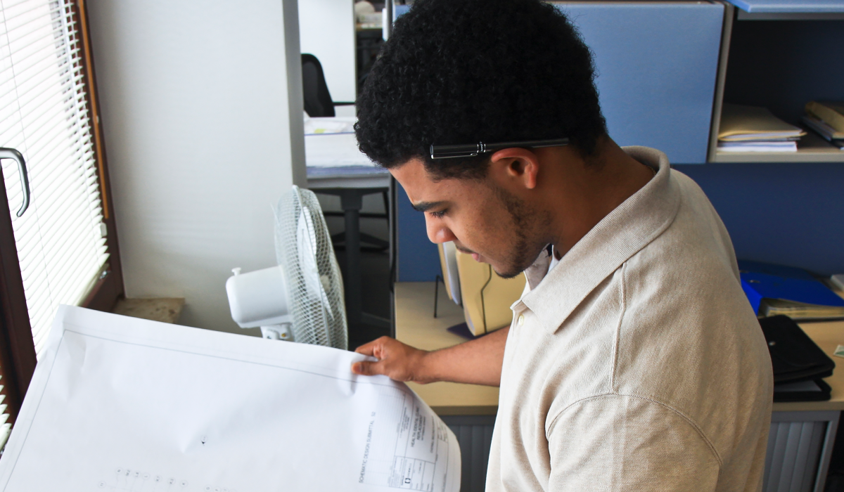 Challenges and Opportunities_ A man looking at drafted schematics.