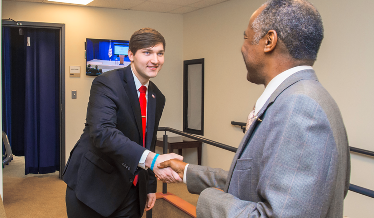 Expanding the Benefits of Internships Two men in suits shaking hands.